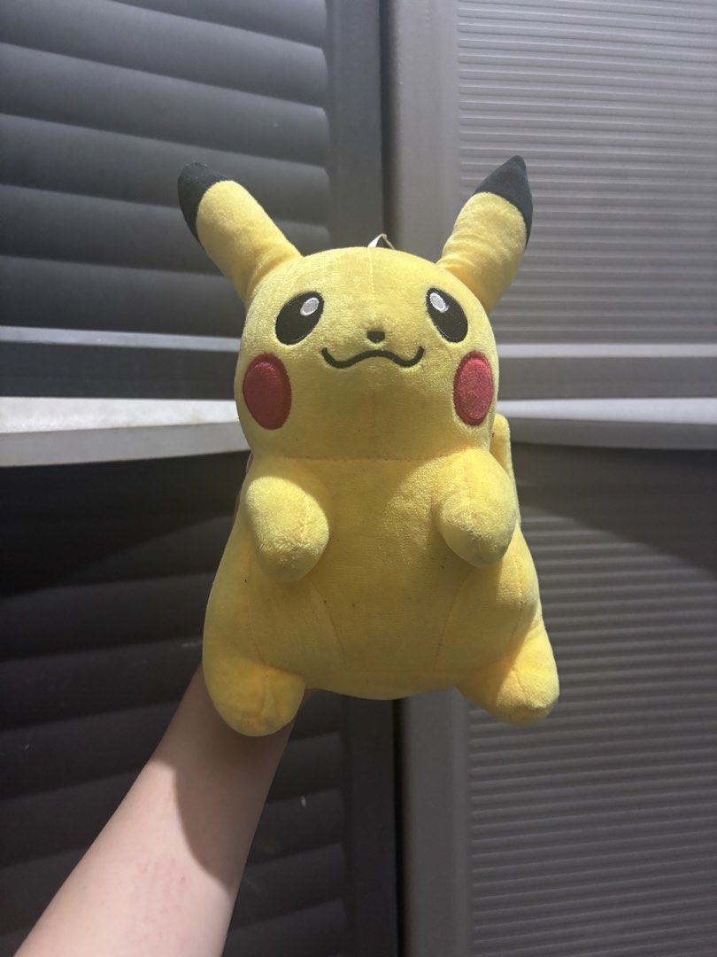 Pokemon Pikachu plush toy (Category: Plushies & Soft Toys) located in Caloocan City. Submitted by aclyy (Listing ID 1470039742, Image 1). Description: - Features classic black-tipped ears, red cheeks, and embroidered eyes - Soft and huggable fabric, great for display or cuddling - Standard medium size - Condition: Overall clean with minor surface wear from storage .
