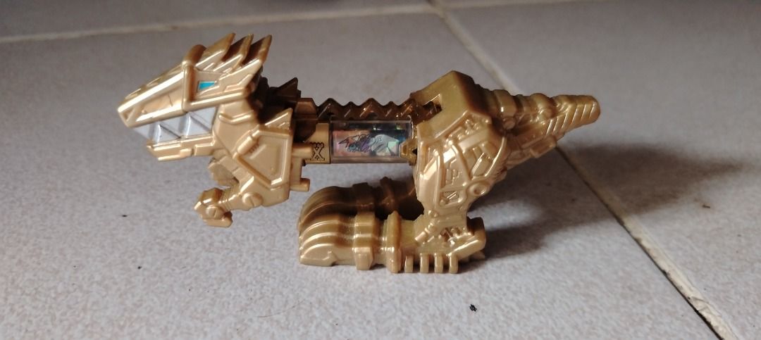 Poweranger Dino charger (Category: Kids Toys) located in Caloocan City. Submitted by mysticrabbit_c00da6 (Listing ID 1470119389, Image 1). Description: - Gold plastic dinosaur figure inspired by Power Rangers Dino Charge - Includes removable battery component - Stands nicely on its own - Great collectible piece for fans of the series - Clean condition with no major scuffs or damage - Ready for display or play.