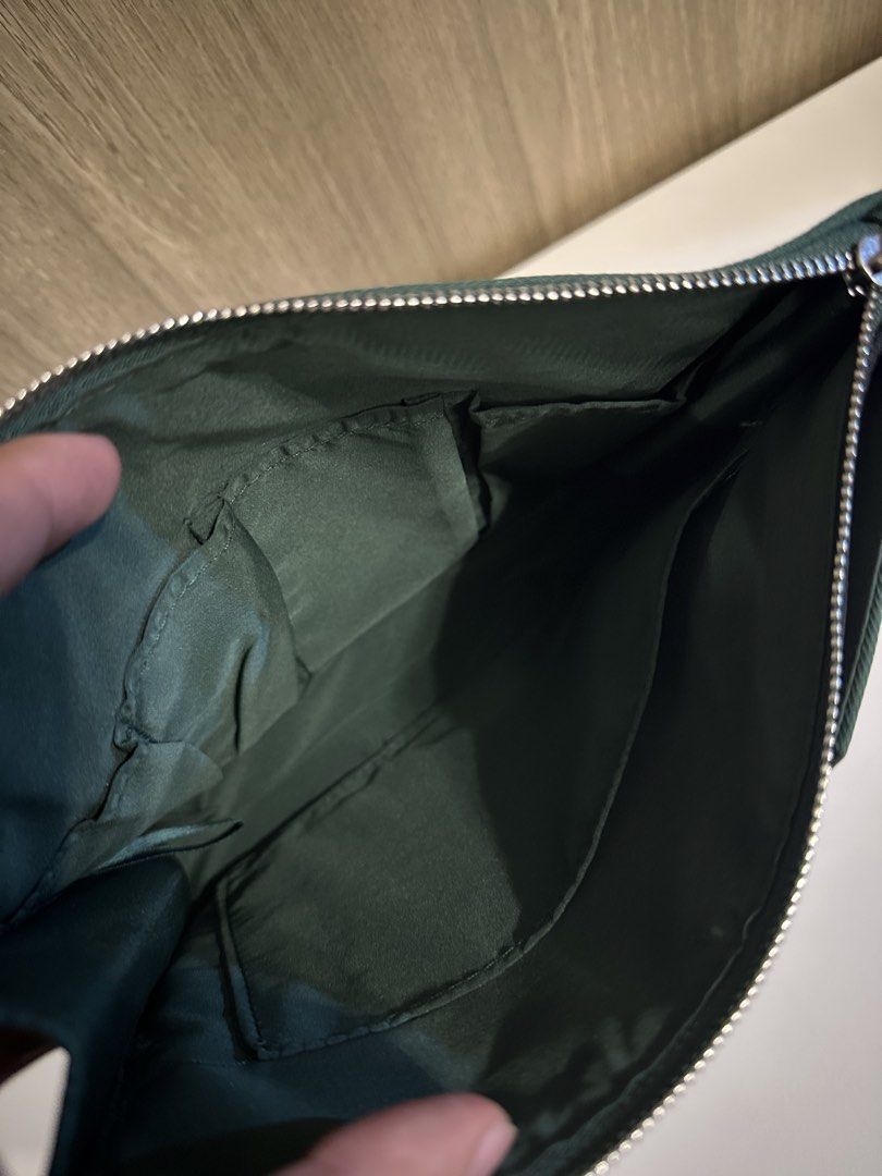 Prada Beauty Green Pouch Makeup Bag (Category: Purses & Pouches) located in Manila. Submitted by kevintotin49861 (Listing ID 1470089653, Image 3). Description: - Authentic Prada Beauty green canvas pouch - Secure zippered top closure with matching green inner lining and pockets - Features the iconic Prada Beauty white label patch and V-shaped black detail - Condition: Clean, zero flaws - Ideal size for daily makeup essentials or travel toiletries