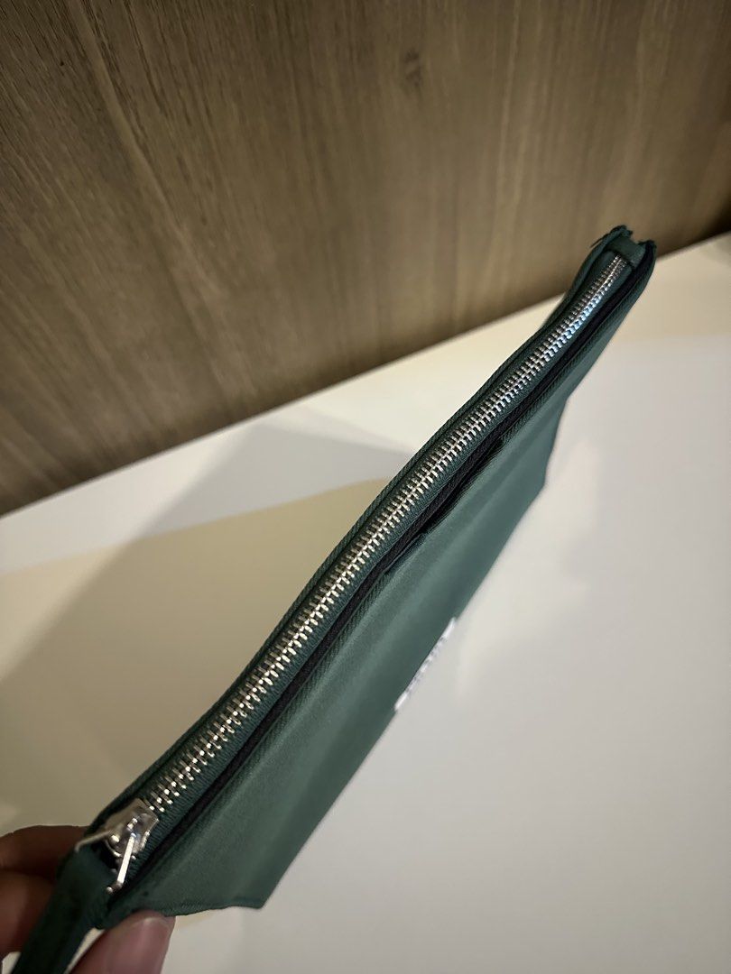Prada Beauty Green Pouch Makeup Bag (Category: Purses & Pouches) located in Manila. Submitted by kevintotin49861 (Listing ID 1470089653, Image 2). Description: - Authentic Prada Beauty green canvas pouch - Secure zippered top closure with matching green inner lining and pockets - Features the iconic Prada Beauty white label patch and V-shaped black detail - Condition: Clean, zero flaws - Ideal size for daily makeup essentials or travel toiletries