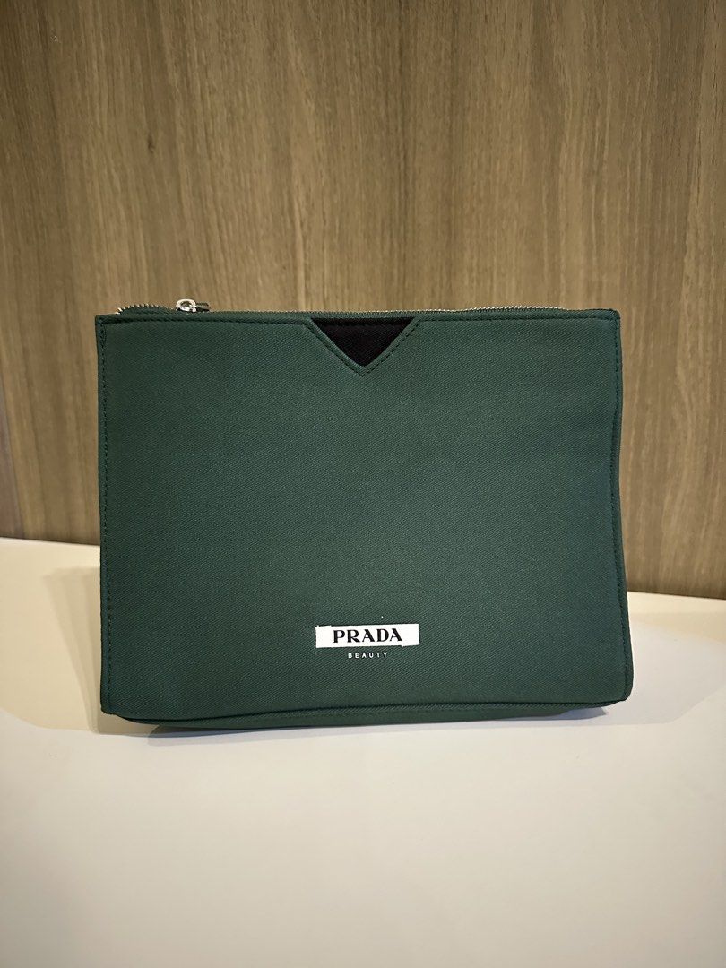 Prada Beauty Green Pouch Makeup Bag (Category: Purses & Pouches) located in Manila. Submitted by kevintotin49861 (Listing ID 1470089653, Image 1). Description: - Authentic Prada Beauty green canvas pouch - Secure zippered top closure with matching green inner lining and pockets - Features the iconic Prada Beauty white label patch and V-shaped black detail - Condition: Clean, zero flaws - Ideal size for daily makeup essentials or travel toiletries