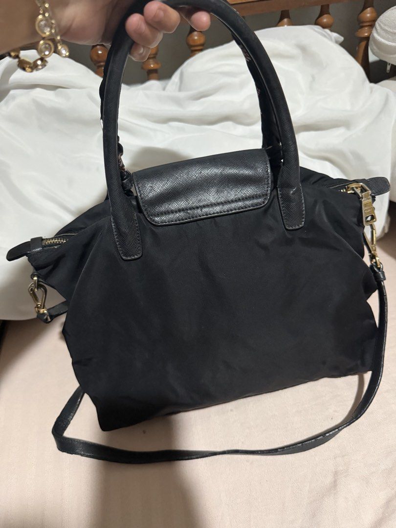 Prada Black Nylon Handbag with strap (Category: Luxury Bags & Wallets) located in San Pablo. Submitted by prelovedbymistyblue (Listing ID 1470051678, Image 2). Description: - Prada black nylon handbag - Features iconic metal triangle logo and leather flap pocket - Gold-tone hardware with top zip closure - Includes top handles wrapped in a stylish patterned twilly scarf - Comes with an adjustable black leather shoulder strap - Condition: Minor fab