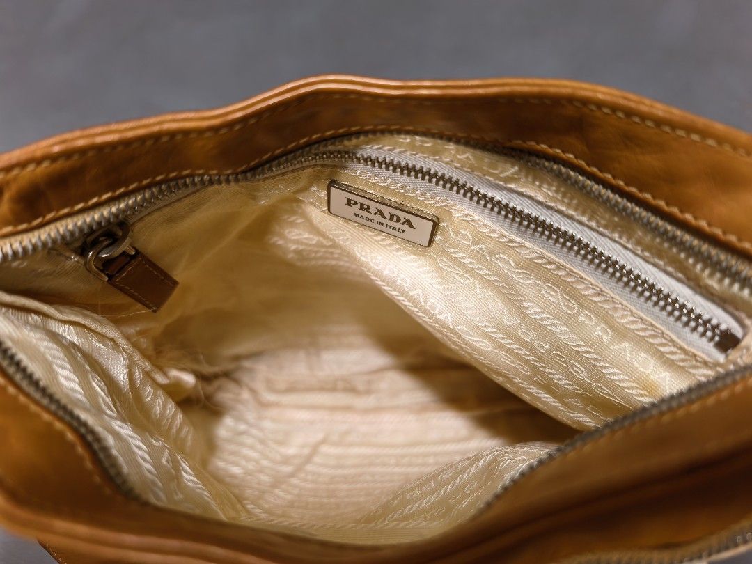 Prada Nylon and Leather Shoulder Bag Cream Brown (Category: Luxury Bags & Wallets) located in Cagayan de Oro. Submitted by pootx (Listing ID 1470092609, Image 3). Description: please check the photos sa mga issues - Authentic vintage Prada shoulder bag - Cream nylon body with brown leather trim - Adjustable strap with silver-tone hardware and Lampo zippers - Front exterior zip pocket and iconic triangular Prada logo plaque - Prada jacquard fabric