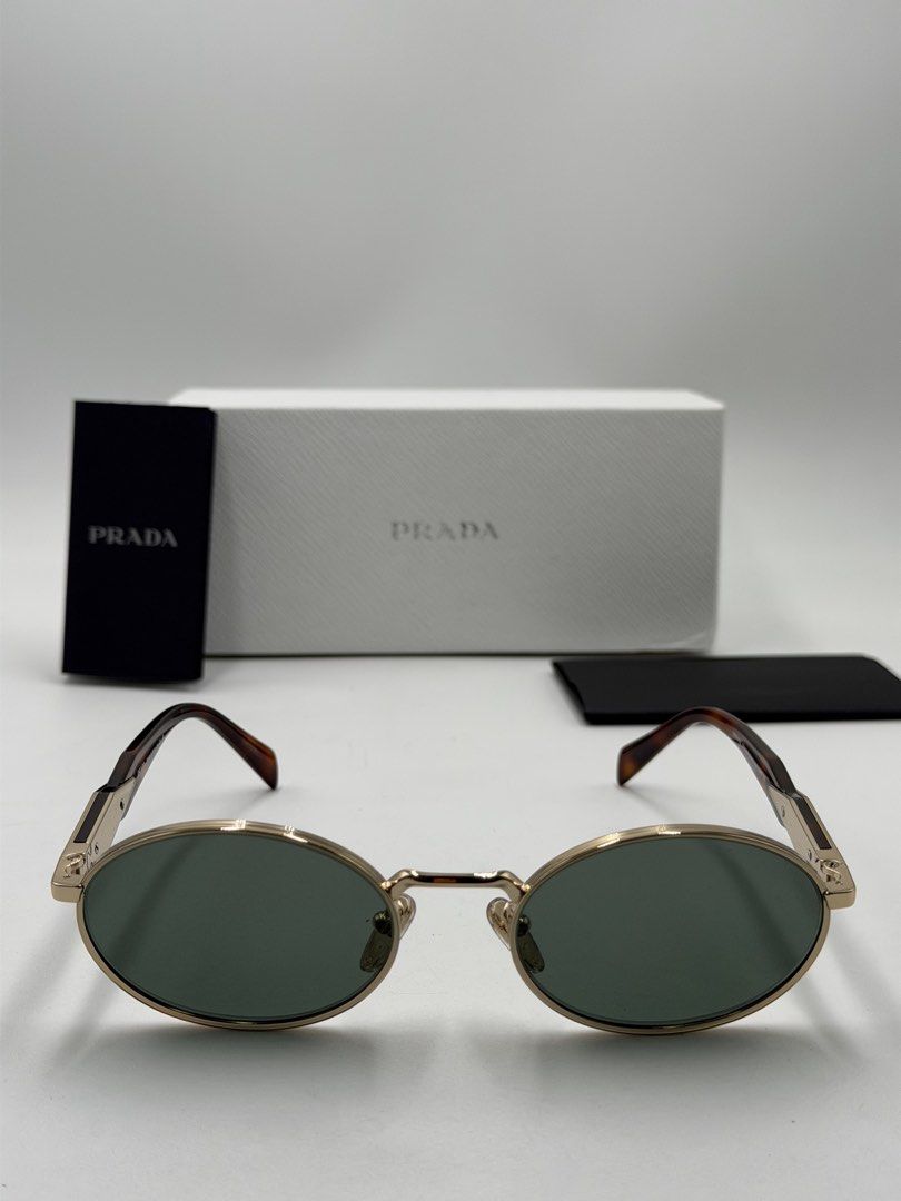 Prada PR 65ZS oval sunglasses (Category: Luxury Accessories) located in Lipa City. Submitted by _cmluxephilippines (Listing ID 1470014948, Image 2). Description: Prada PR 65ZS oval sunglasses. This design from the Prada Eyewear Collection features a minimalist pale gold metal full-rim front, classic dark green lenses, and signature geometric temples detailed with tortoiseshell acetate tips and the engraved Prada Milano plaque.