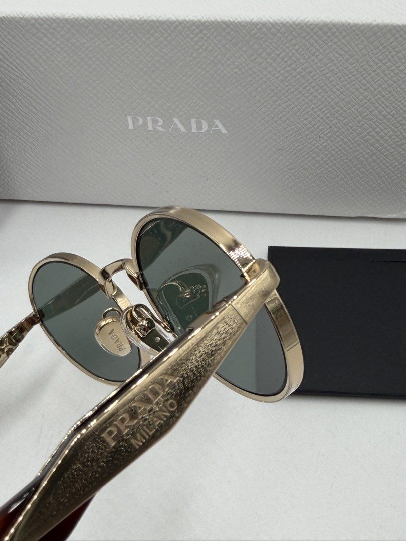 Prada PR 65ZS oval sunglasses (Category: Luxury Accessories) located in Lipa City. Submitted by _cmluxephilippines (Listing ID 1470014948, Image 3). Description: Prada PR 65ZS oval sunglasses. This design from the Prada Eyewear Collection features a minimalist pale gold metal full-rim front, classic dark green lenses, and signature geometric temples detailed with tortoiseshell acetate tips and the engraved Prada Milano plaque.