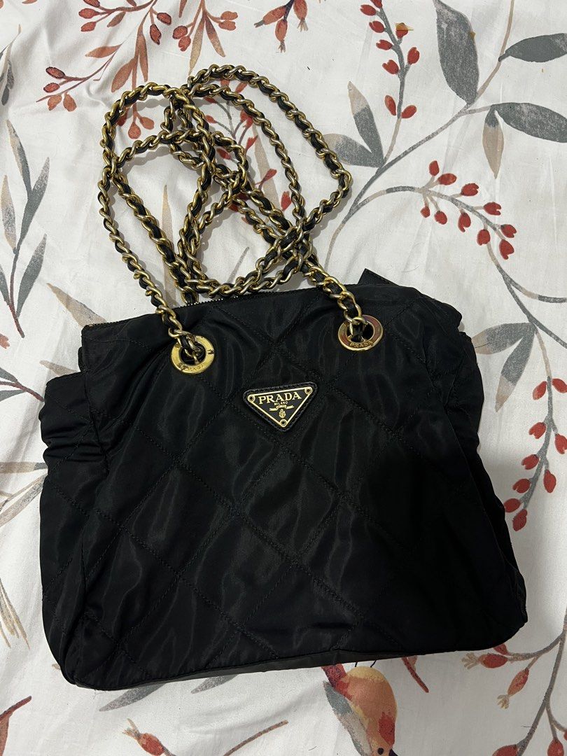 Prada Quilted Nylon Chain Shoulder Bag Black (Category: Luxury Bags & Wallets) located in Antipolo. Submitted by cdro627734 (Listing ID 1470083633, Image 2). Description: - Authentic Prada shoulder bag in classic black quilted nylon - Features the iconic metal triangle logo on the front - Elegant gold-tone hardware paired with black leather-woven chain straps - Secure top zipper closure to keep your belongings safe - Roomy interior fits all your 