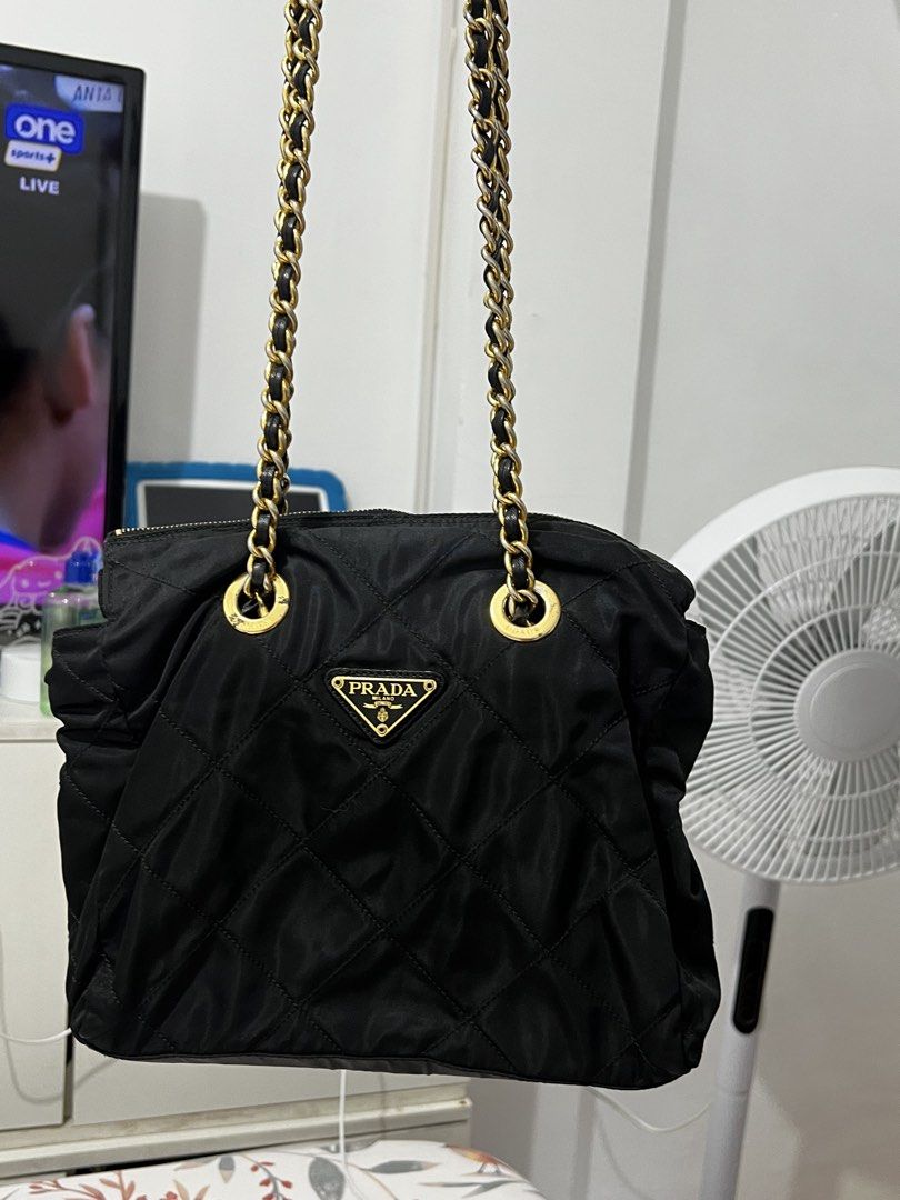 Prada Quilted Nylon Chain Shoulder Bag Black (Category: Luxury Bags & Wallets) located in Antipolo. Submitted by cdro627734 (Listing ID 1470083633, Image 3). Description: - Authentic Prada shoulder bag in classic black quilted nylon - Features the iconic metal triangle logo on the front - Elegant gold-tone hardware paired with black leather-woven chain straps - Secure top zipper closure to keep your belongings safe - Roomy interior fits all your 
