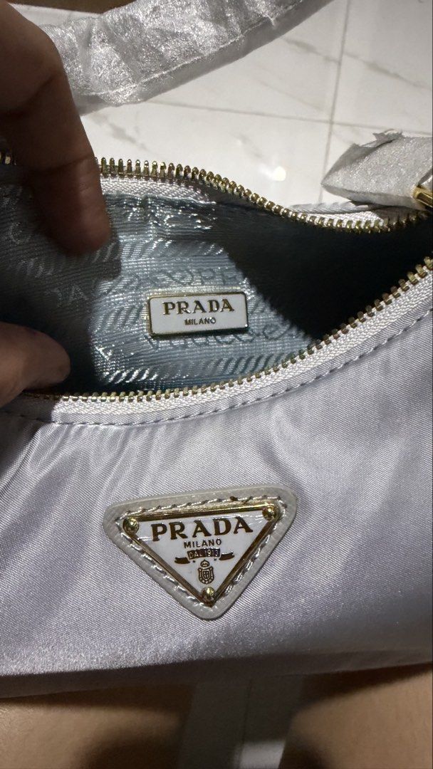 Prada Re-Edition 2004 Vit. Dainoprint Handbag (Category: Luxury Bags & Wallets) located in Kabacan. Submitted by khristine_ga (Listing ID 1470056038, Image 3). Description: - Brand: Prada - Model: 1BH204 Vit. Dainoprint - Color: Grey - Hardware: Gold-tone - Closure: Zip closure - Logo: Signature front triangle logo - Interior: Patterned fabric lining with 'Made in Italy' tag and factory number tag - Condition: Brand new with tag, authenticity car