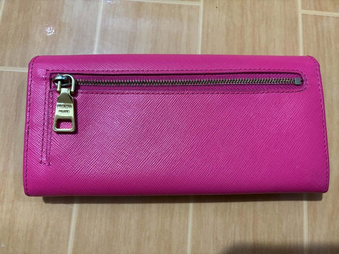 Prada Saffiano Leather Long Flap Wallet Pink (Category: Luxury Bags & Wallets) located in Paranaque City. Submitted by poego (Listing ID 1469975664, Image 2). Description: - Authentic Prada long wallet in bright pink Saffiano leather - Elegant gold-tone hardware with front Prada lettering logo - Secure flap closure with snap buttons - Convenient back zipped pocket with gold zipper pull - Well-organized interior with multiple card slots and compar