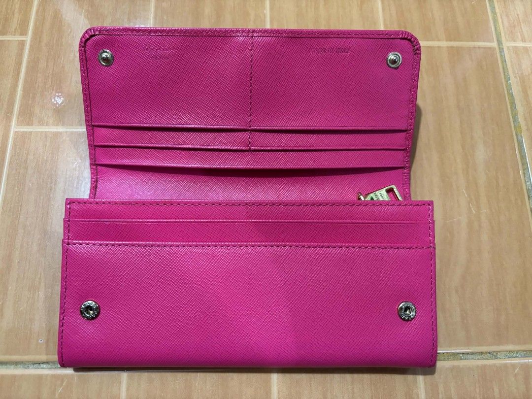 Prada Saffiano Leather Long Flap Wallet Pink (Category: Luxury Bags & Wallets) located in Paranaque City. Submitted by poego (Listing ID 1469975664, Image 3). Description: - Authentic Prada long wallet in bright pink Saffiano leather - Elegant gold-tone hardware with front Prada lettering logo - Secure flap closure with snap buttons - Convenient back zipped pocket with gold zipper pull - Well-organized interior with multiple card slots and compar