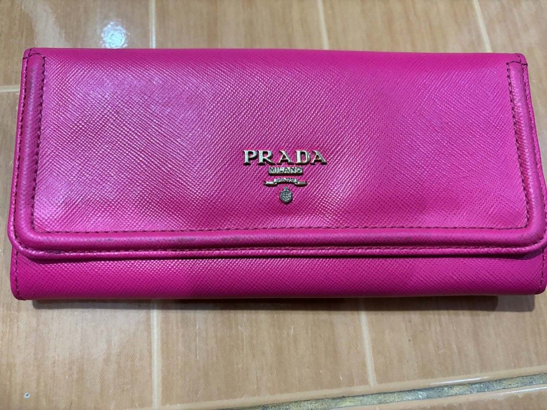 Prada Saffiano Leather Long Flap Wallet Pink (Category: Luxury Bags & Wallets) located in Paranaque City. Submitted by poego (Listing ID 1469975664, Image 1). Description: - Authentic Prada long wallet in bright pink Saffiano leather - Elegant gold-tone hardware with front Prada lettering logo - Secure flap closure with snap buttons - Convenient back zipped pocket with gold zipper pull - Well-organized interior with multiple card slots and compar