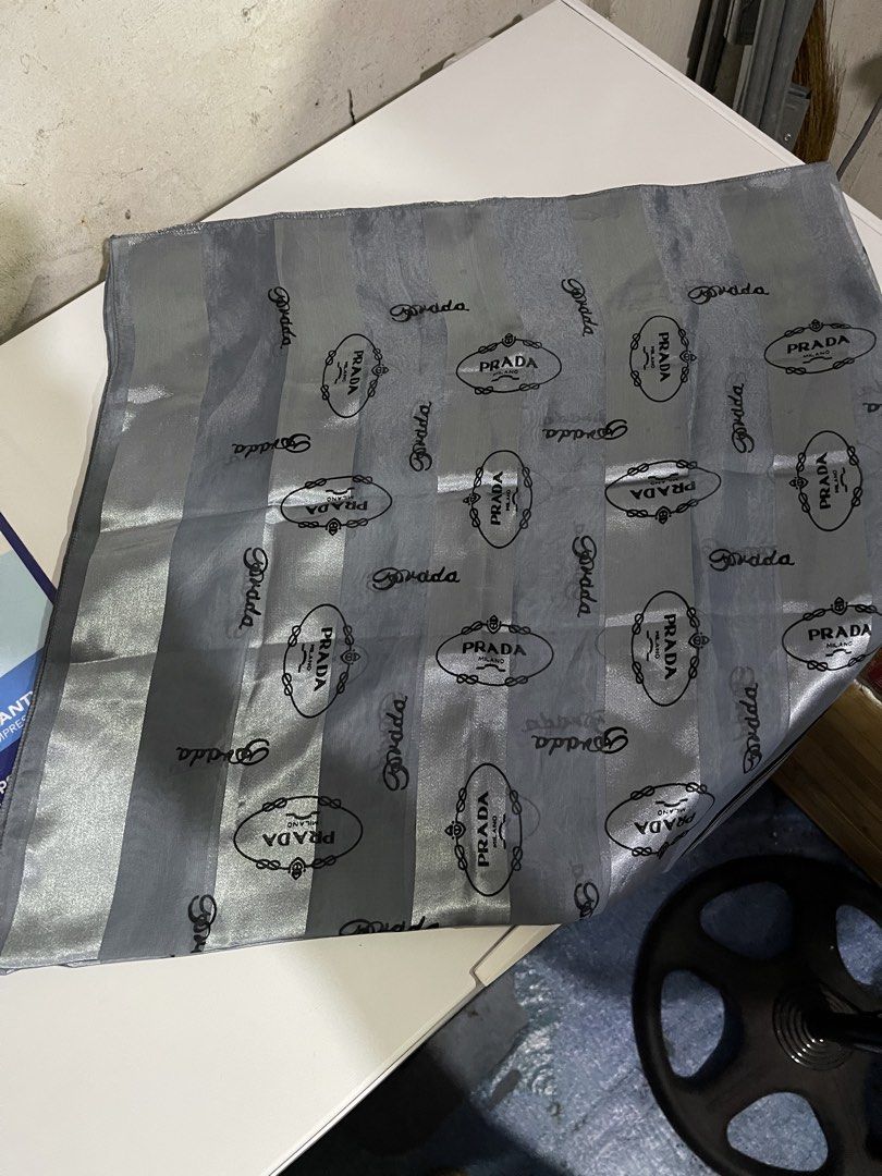 Prada Striped Silk Scarf Grey (Category: Luxury Accessories) located in Mandaluyong City. Submitted by mark2pac (Listing ID 1470054098, Image 1). Description: - Authentic Prada grey and silver striped scarf - Features repeating Prada Milano logo print and large center diamond graphic - Lightweight material with a smooth texture - Versatile size, perfect for styling around the neck or bag - Clean fabric with no pulls or stains - Sourced from a smo