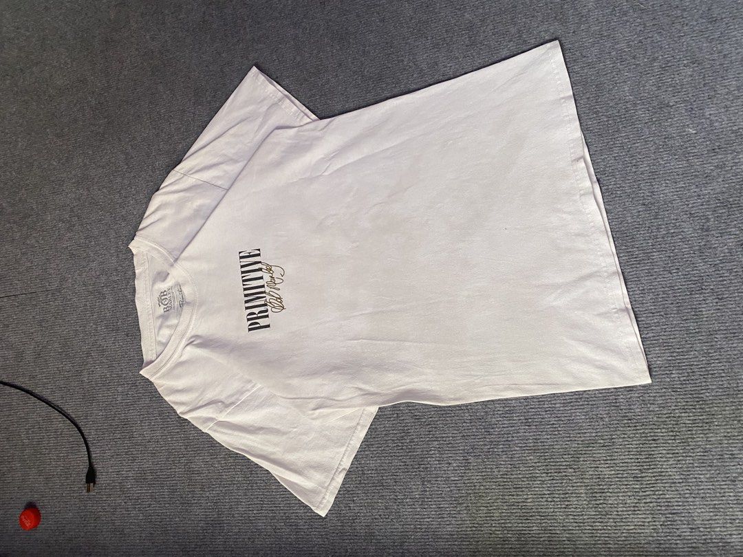 Primitive x Bob Marley White Graphic Tee (Category: Tshirts & Polo Shirts ) located in Maria Aurora. Submitted by mightypenguin.f7ca53 (Listing ID 1470057087, Image 1). Description: White graphic tee from the Primitive and Bob Marley collaboration. Front features Primitive lettering and Bob Marley's signature in gold. Back has a large photo graphic of Bob Marley performing alongside the quote "My music will go on forever." Tagged size and materia