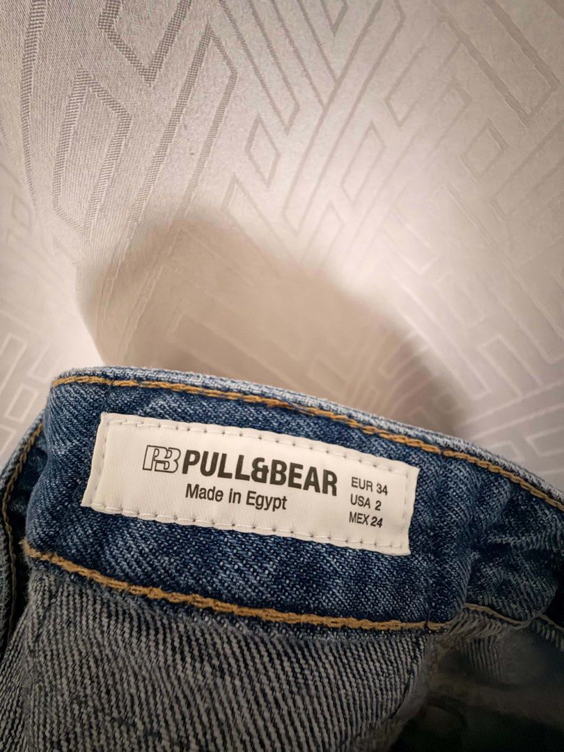 Pull & Bear Blue High Waist Raw Hem Jeans (Category: Jeans) located in Manila. Submitted by janellecas75114 (Listing ID 1470074632, Image 2). Description: - Brand: Pull & Bear - Wash: Classic blue - Size: EUR 34, USA 2, MEX 24 - Fit: High waist with structured waistband and belt loops - Details: Trendy raw frayed ankle hem, standard button/zip fly, and classic 5-pocket setup with contrast stitching - Condition: Clean and well-maintained.