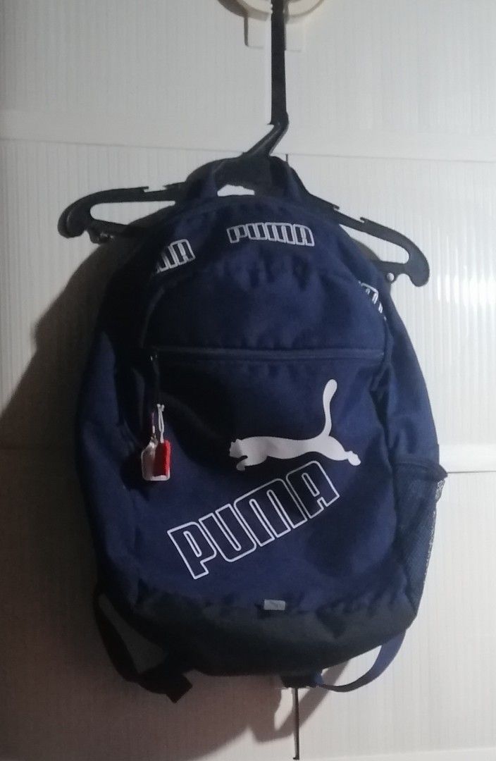 Puma Navy Blue Backpack with White Logos (Category: Backpacks) located in Quezon City. Submitted by rolenalma (Listing ID 1470106967, Image 2). Description: - Authentic navy blue Puma backpack with bold white logo branding - Storage features: Front zippered pocket, side mesh pockets, and interior slip pocket with signature lining - Comfort & Safety: Adjustable, padded shoulder straps with reflective strips - Versatile use: Ideal for daily school 