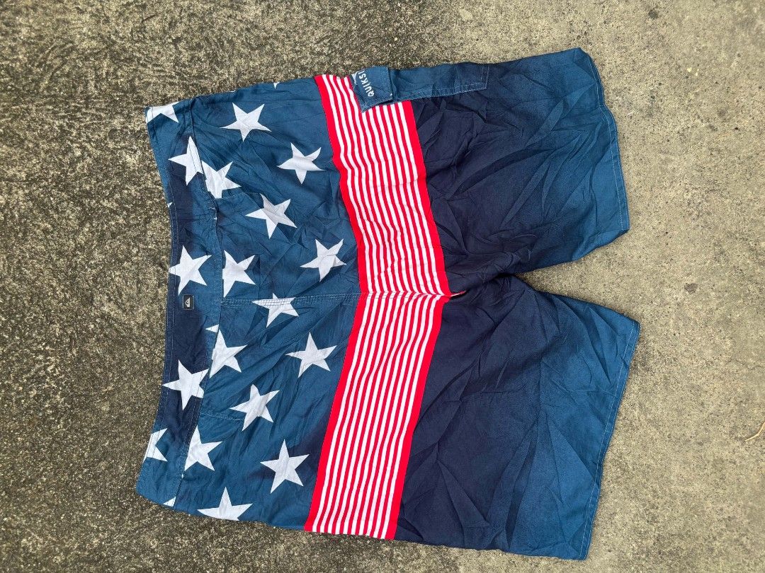 Quiksilver USA Flag Boardshorts Size 36 (Category: Swim Trunks & Board Shorts) located in Manila. Submitted by lawrence_escutin (Listing ID 1470001608, Image 2). Description: - Brand: Quiksilver - Style: American flag theme (stars, stripes, and solid dark blue) - Size: 36 (tagged on inner waistband) - Features: Side cargo pocket, secure drawstring waist with metal eyelets, and Quiksilver logo patch - Condition: Good, ready for the beach or pool -