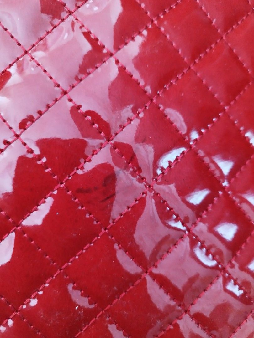 Red Quilted Patent Leather Handbag (Category: Luxury Bags & Wallets) located in Cavite. Submitted by RAJATREASUREBOX (Listing ID 1469991533, Image 3). Description: - Color/Material: Bright red glossy patent leather - Design: Quilted diamond pattern with silver hardware - Closure: Secure top zipper - Strap: Matching red strap with silver metal clasps - Size: Compact, ideal for daily essentials - Condition: Good, with a minor dark scuff mark near t