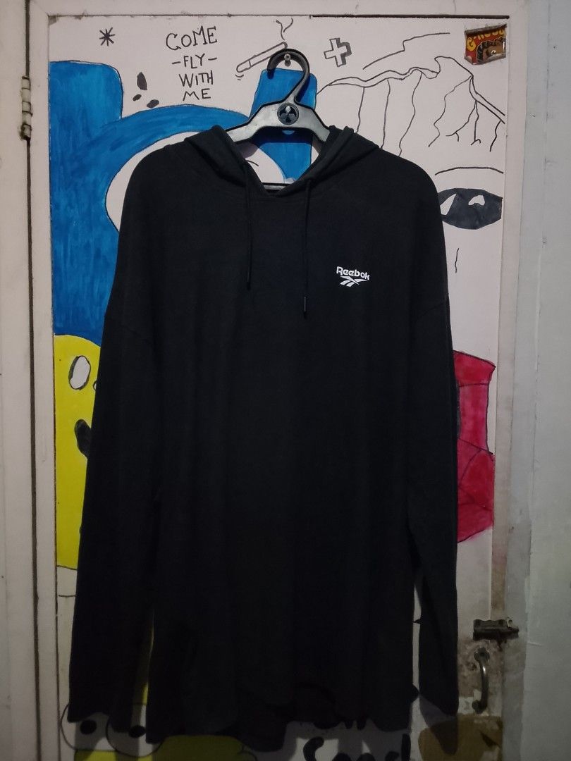 Reebok Black Hoodie with Big Vector Logo Back (Category: Hoodies) located in Manila. Submitted by warmcloud-06f3 (Listing ID 1469954018, Image 2). Description: - Brand: Reebok - Color: Black - Size: Standard fit - Material: Cozy cotton blend - Design: Small chest logo & large white vector logo on upper back - Features: Long sleeves, adjustable drawstrings, ribbed cuffs and hem - Condition: Clean, no obvious flaws - Best for: Daily casual wear or 