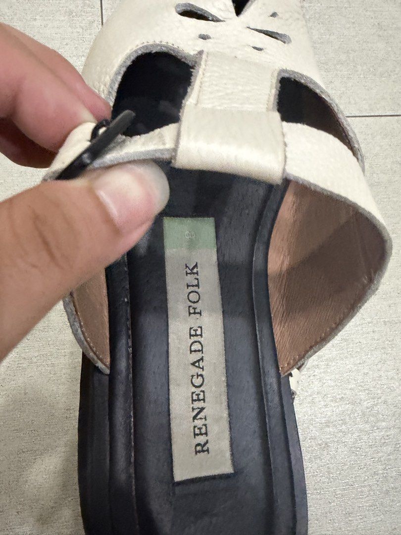Renegade Folk Mules (Size 8) (Category: Flats & Sandals) located in Davao. Submitted by pamdyclutters (Listing ID 1470072165, Image 3). Description: - Brand: Renegade Folk - Size: US 8 / PH equivalent - Color: White leather with chunky black soles - Features: Floral cutout upper strap and adjustable side buckle for secure fit - Traction: Grooved soles for anti-slip grip - Condition: Excellent, minimal wear on soles and footbeds.