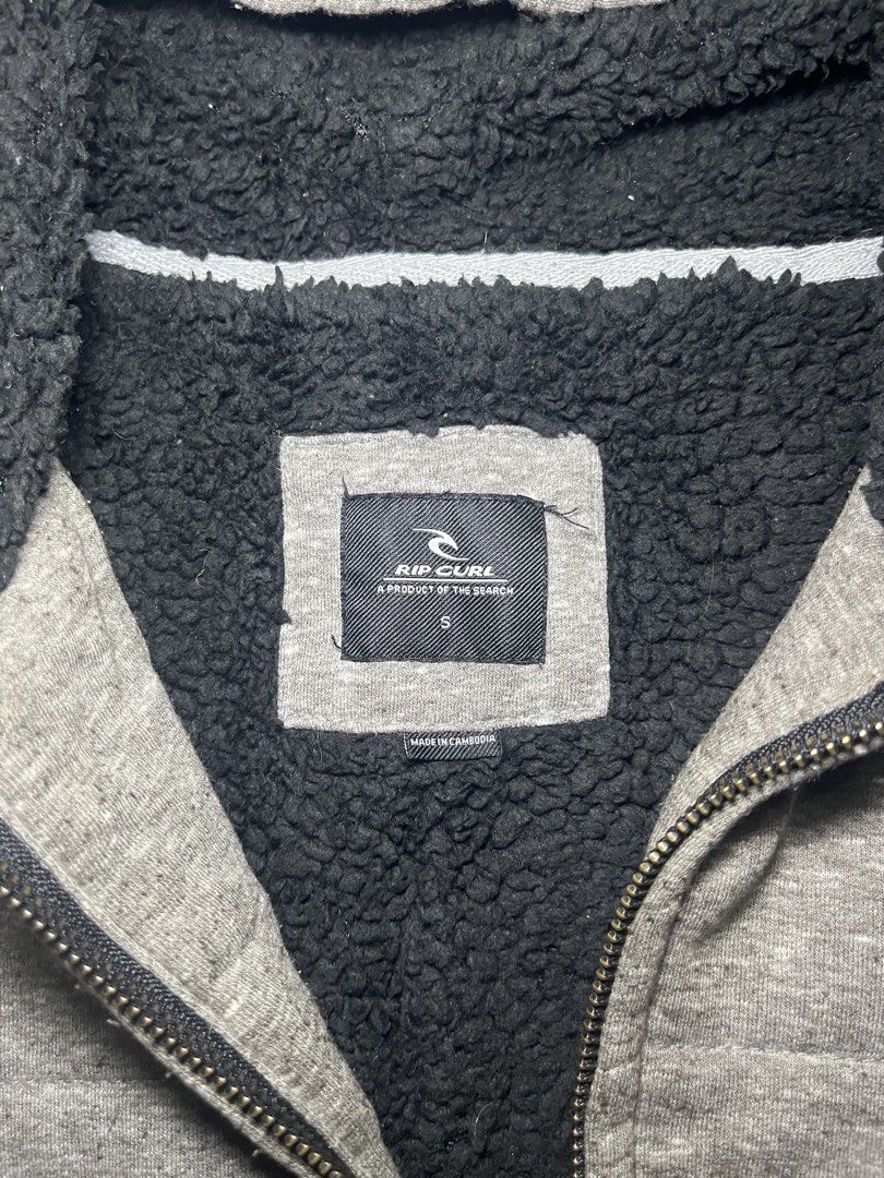 Rip Curl Sherpa Lined Grey Zip Hoodie Size S (Category: Coats, Jackets and Outerwear) located in Muntinlupa City. Submitted by pastforwardthrift (Listing ID 1470124088, Image 3). Description: - Brand: Rip Curl - Size: Small - Color: Grey with soft black sherpa lining inside the hood and body - Features: Front split kangaroo pocket and branded metal zipper pull - Origin: Made in Cambodia - Condition: Great for keeping warm and stylish during cold 