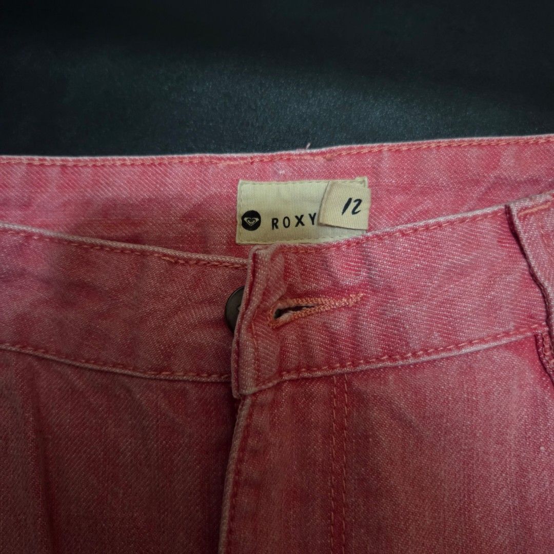 Roxy Pink Denim Skirt Size 12 (Category: Skirts) located in Makati City. Submitted by lexshie (Listing ID 1469977890, Image 2). Description: - Brand/Style: Roxy denim skirt in a trendy washed pink - Size: 12 (tagged on waistband) - Design details: Raw frayed hemline with slight distressing on the pockets - Features: Classic five-pocket styling, zipper fly, and button closure - Accents: Small Roxy leather patch on the back pocket - Condition/Vibe: