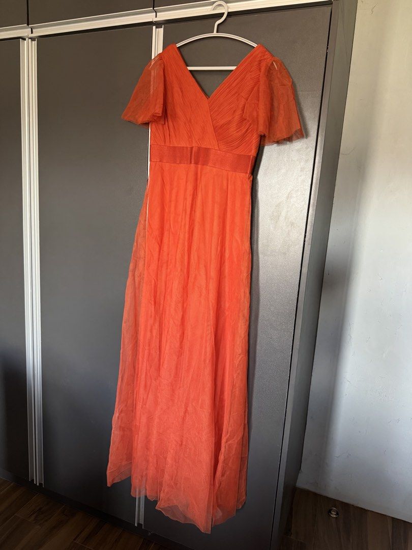 Rusty Orange Dress Gown Flared Sleeves (Category: Dresses) located in Dasmarinas. Submitted by akelvin23 (Listing ID 1470112373, Image 1). Description: - Style: V-neck maxi dress with flowy tulle skirt overlay - Color: Vibrant orange - Details: Pleated bodice, sheer flared sleeves, and satin waistband - Closure: Concealed back zipper - Condition: Worn once, dry-cleaned, no stains or tears Waist - 29 in Shoulder - 15.5 in Bust - 33 in approx Lengt