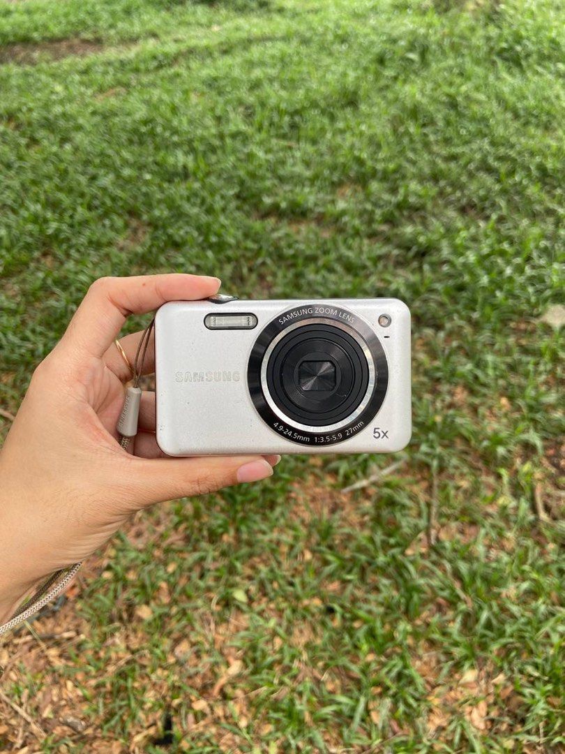 Samsung es75 Digital Camera 5x Zoom Lens (Category: Cameras) located in Davao. Submitted by nnnnnaaaamt (Listing ID 1470076599, Image 1). Description: - Model: Samsung es75 Compact Digital Camera - Color: Silver - Condition: Powers on and shoots well - Features: 5x zoom lens, built-in flash, attached wrist strap - Portability: Pocket-sized and lightweight, easy to carry in small bags - Best for: Casual everyday snapshots and street photography.