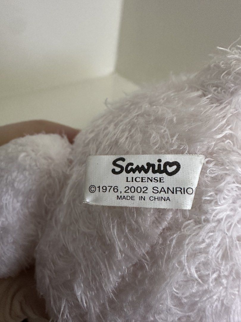 Sanrio Hello Kitty Bear Plush Toy 2002 (Category: Plushies & Soft Toys) located in Quezon City. Submitted by swift.thriftz (Listing ID 1470121471, Image 2). Description: - Official Sanrio Kitty plush toy with 1976/2002 license - Adorable design dressed in a fuzzy white bear hoodie with pink accents - Features a red bow on the hood and a larger red ribbon with Kitty lettering around the neck - Cute pink paws detailed with golden Kitty text ribbon.