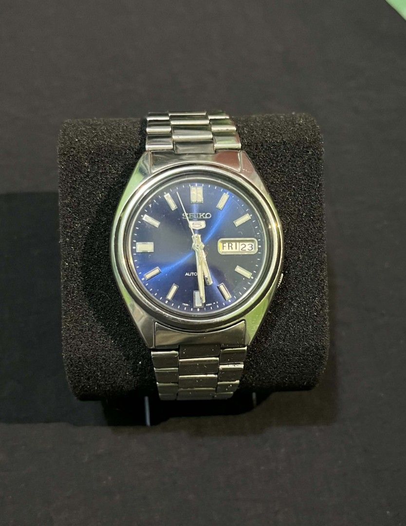 Seiko 5 Automatic Blue Dial Watch (Category: Men's Watches) located in Cebu City. Submitted by jbok_watches. (Listing ID 1470101133, Image 1). Description: - Brand: Seiko 5 Automatic Watch - Dial: Striking blue sunburst dial with 3 o'clock day/date window - Material: Stainless steel case and matching metal bracelet with signed clasp - Movement: Automatic movement visible through the exhibition case back - Condition: Classic everyday timepiece wit