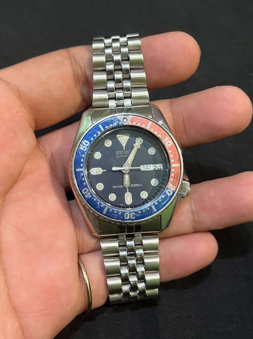 Seiko Automatic Pepsi Diver 200m Watch (Category: Men's Watches) located in Cebu City. Submitted by jbok_watches. (Listing ID 1470102197, Image 3). Description: - Authentic Seiko automatic diver watch - Iconic blue and red Pepsi bezel with dark dial - Day and date display at the 3 o'clock position - Stainless steel jubilee-style bracelet with secure clasp - Luminous hands and hour markers for low-light visibility - Screw-down crown located at the