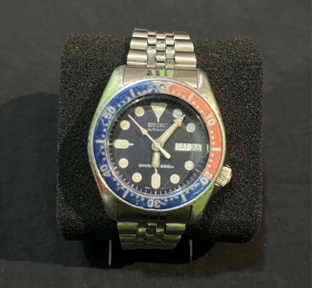 Seiko Automatic Pepsi Diver 200m Watch (Category: Men's Watches) located in Cebu City. Submitted by jbok_watches. (Listing ID 1470102197, Image 1). Description: - Authentic Seiko automatic diver watch - Iconic blue and red Pepsi bezel with dark dial - Day and date display at the 3 o'clock position - Stainless steel jubilee-style bracelet with secure clasp - Luminous hands and hour markers for low-light visibility - Screw-down crown located at the
