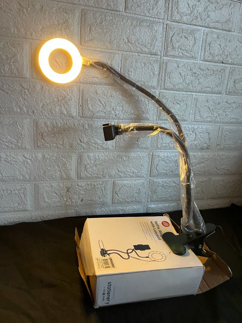 Selfie Ring Light w/ Lazypod (Category: Lighting & Studio Equipment) located in Quezon City. Submitted by shime_diel (Listing ID 1470118194, Image 2). Description: Comes with 3 light intensities: 1. Pure white 2. Middle tone 3. Warm tone The box's contents are: - 1 Ringlight - 1 Phone Holder - Wire with USB Type A I have used this mainly for recording in a small space.