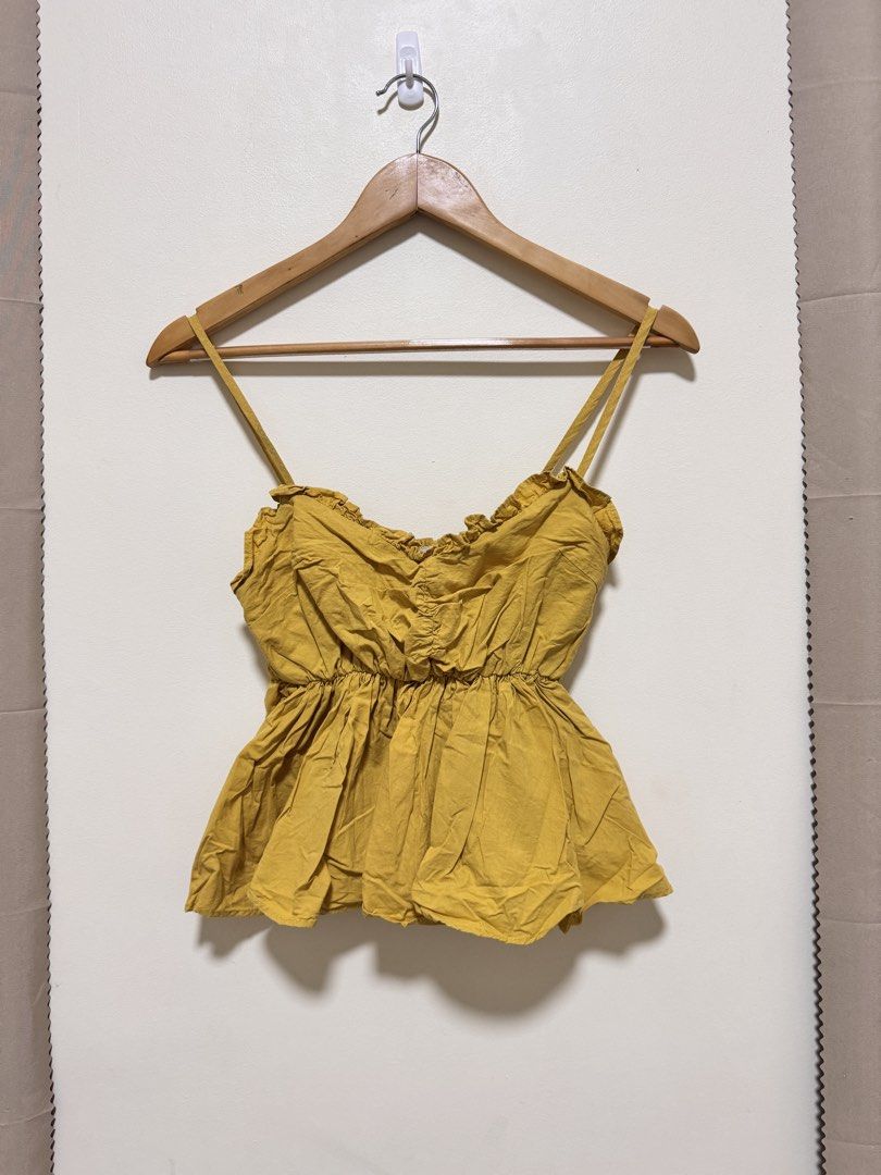 Sexy Top (Category: Sleeveless) located in Manila. Submitted by seayouncey (Listing ID 1470059272, Image 1). Description: - Color: Mustard yellow - Neckline: Sweetheart with delicate ruffle trim - Straps: Adjustable spaghetti straps - Fit: Stretchy smocked bodice and back - Style: Flared flowy peplum waist - Fabric: Lightweight and breathable for warm weather - Versatility: Perfect to pair with denim shorts or a casual skirt.