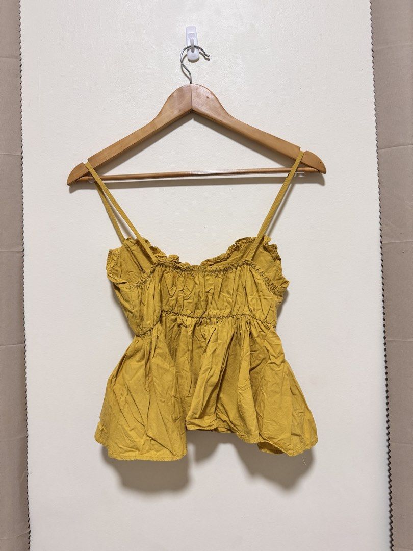 Sexy Top (Category: Sleeveless) located in Manila. Submitted by seayouncey (Listing ID 1470059272, Image 2). Description: - Color: Mustard yellow - Neckline: Sweetheart with delicate ruffle trim - Straps: Adjustable spaghetti straps - Fit: Stretchy smocked bodice and back - Style: Flared flowy peplum waist - Fabric: Lightweight and breathable for warm weather - Versatility: Perfect to pair with denim shorts or a casual skirt.