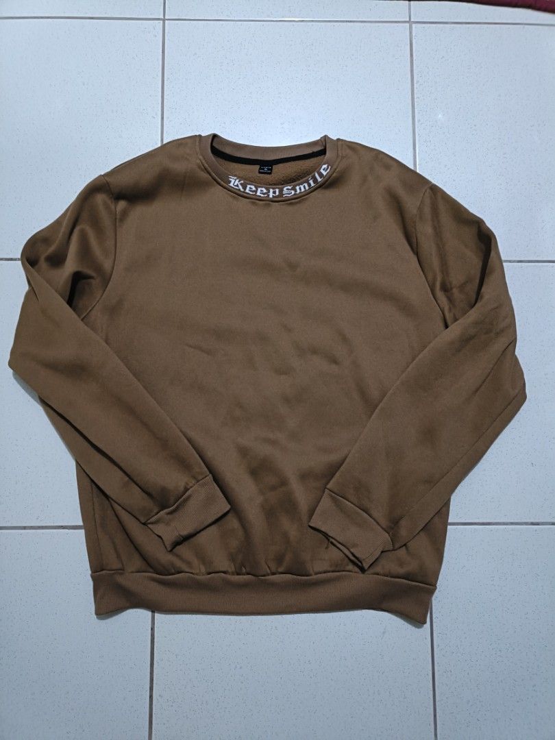 SHEIN Keep Smile Brown Sweatshirt Size (Category: Coats, Jackets and Outerwear) located in Manila. Submitted by quartz.rewind (Listing ID 1470111486, Image 1). Description: "🔥 10% OFF if you buy any 2 items! / 15% OFF for 3+ items. Shipping can be combined to save you money. Valid this week only!" Description: Up for grabs is a cozy coffee-brown crewneck sweatshirt from SHEIN. Features a unique white gothic text detail knitted along the collar r