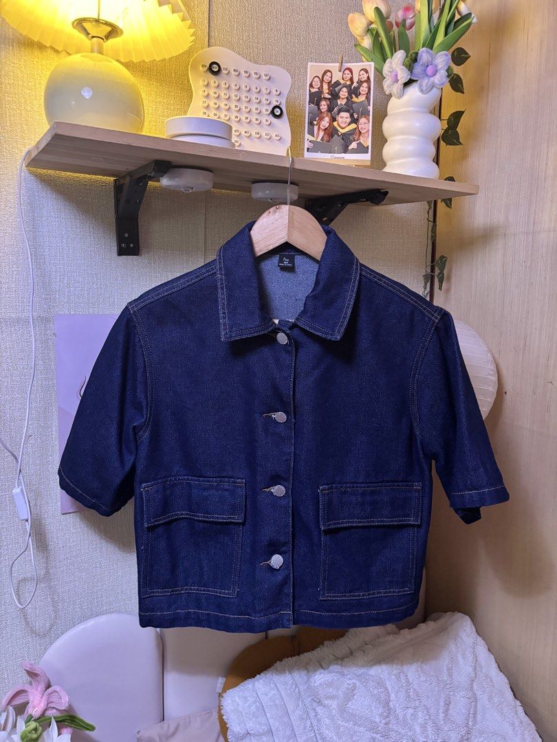 SHEIN Petite Short Sleeve Denim Jacket (Category: Shirts) located in Manila. Submitted by joe_fashion1234 (Listing ID 1470136727, Image 2). Description: - Brand: SHEIN Petite - Color: Dark wash denim with contrasting yellow stitching - Style: Short sleeves, front button closure, classic collar - Features: Two large chest pockets, structured fit - Condition: Clean overall, perfect for casual layering.
