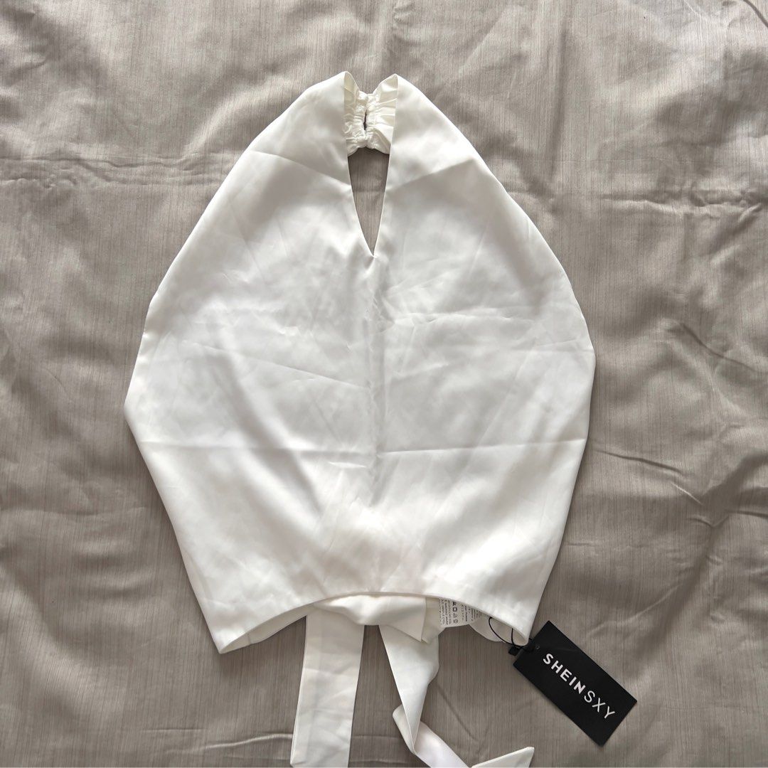 SHEINSXY White Halter Tie-Back Satin Top (Category: Sleeveless) located in Pasig City. Submitted by jenscloset86 (Listing ID 1470028553, Image 1). Description: Brand: SHEIN Size: Medium (best fit Small-Medium) BRAND NEW • BRAND NEW • Never used, never worn. • No flaws, no damages. Measurement: Length: 27” Bust: 30-34” when stretched Waist: 26-28”.