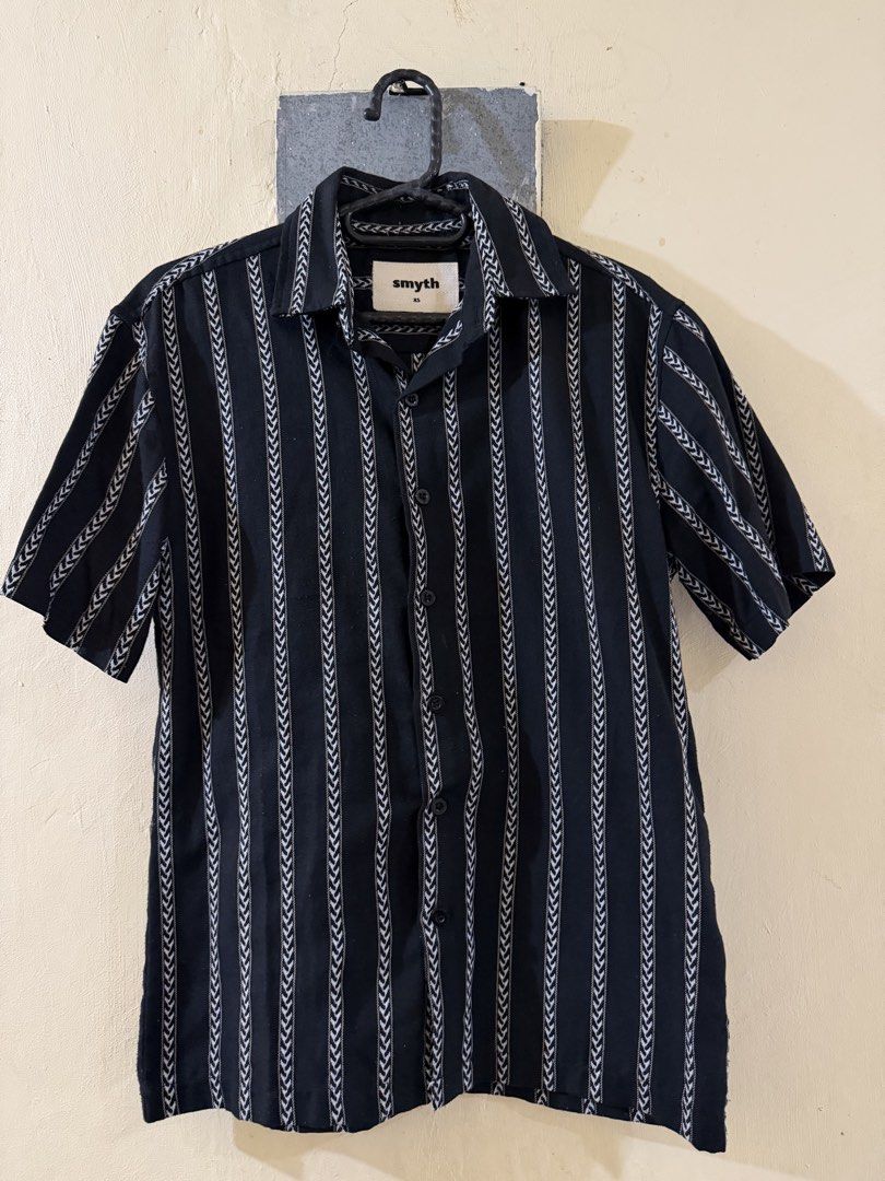 Short Sleeve Button Up Shirt Black White Stripe (Category: Tshirts & Polo Shirts ) located in Las Pinas. Submitted by rareriroruru (Listing ID 1470055655, Image 1). Description: - Brand: Smyth - Color: Black with white vertical chevron stripes - Style: Short sleeves, camp collar, front button closure - Size: Extra Small (XS) - Length: 25 in - Width: 18 in - Condition: Clean fabric, no flaws, ready to wear.