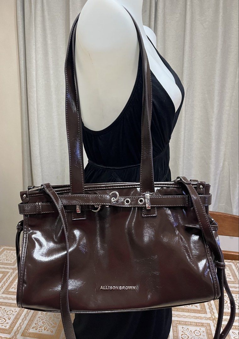 Shoulder bag (Category: Shoulder Bags) located in Bacoor. Submitted by ayit. (Listing ID 1470067719, Image 1). Description: Bnew japan gling orig - Brand: Allison Brown - Color: Glossy dark brown - Style: Shoulder bag / Crossbody bag - Features dual top handles and a detachable, adjustable long strap - Spacious main compartment with interior zipper and slip pockets - Chic belt and metal ring accent on the front - Condition: Well-maintained and re