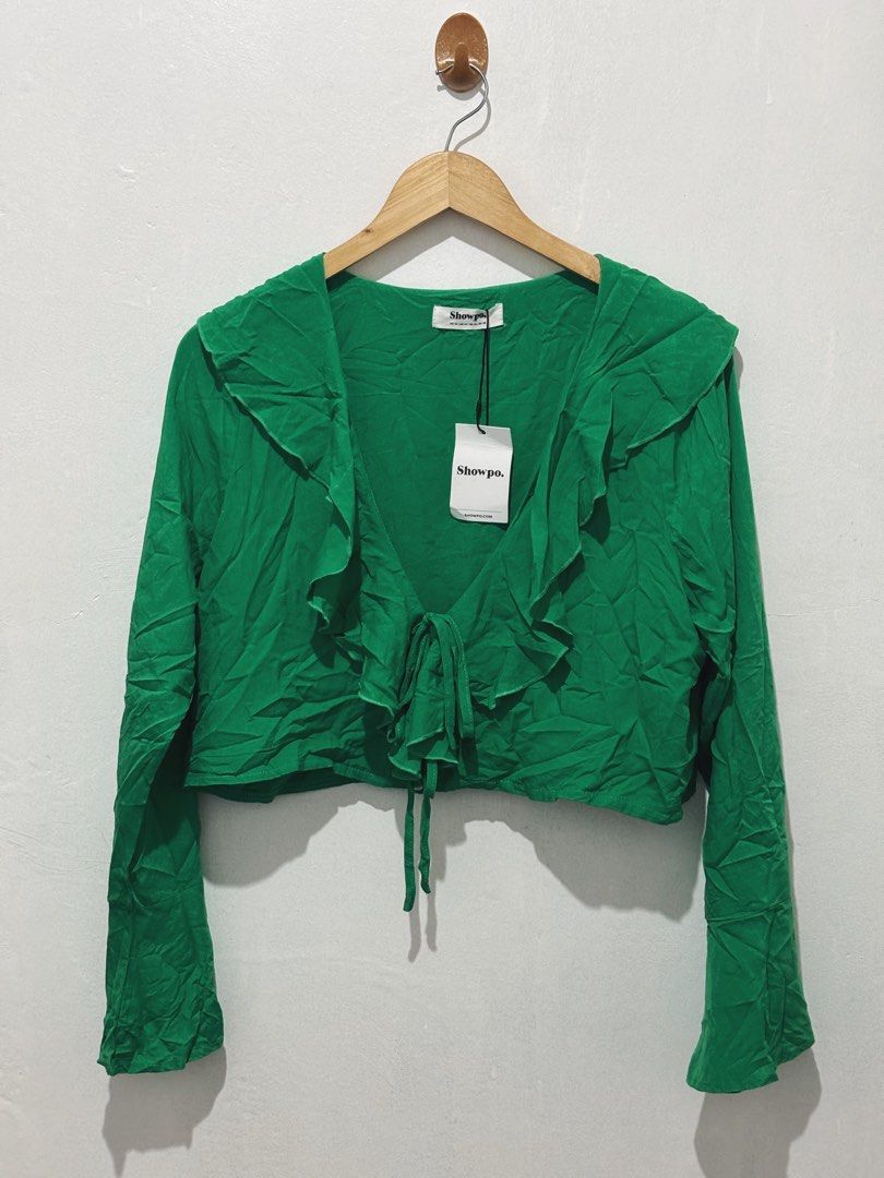 SHOWPO GREEN RUFFLE CROP TOP WITH TIE FRONT (Category: Sleeveless) located in Angeles City. Submitted by chic.haven (Listing ID 1470038579, Image 1). Description: - Brand: Showpo - Color: Bright green - Style: Long sleeve crop top with ruffled shawl collar and front tie closure - Material: Lightweight fabric - Condition: Brand new with brand tag and hang tag attached (slightly wrinkled from storage) - Perfect for beach cover up.