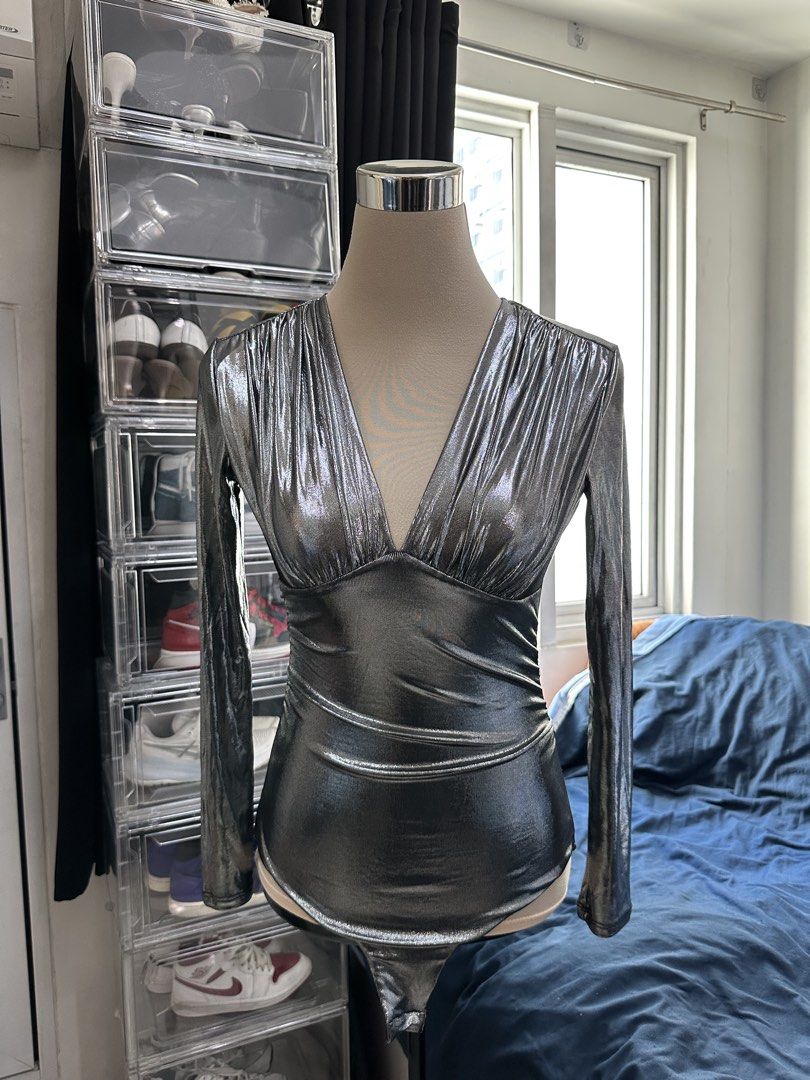 Silver Metallic Long Sleeve V-Neck Bodysuit (Category: Longsleeves) located in Quezon City. Submitted by valeriorac74670 (Listing ID 1470044814, Image 1). Description: - Color: Metallic silver - Design: Long sleeves with a deep V-neckline and gathered chest pleats - Fit: Fitted torso with flattering ruching details - Closure: Snap button closure at the bottom - Occasion: Ideal for parties, clubs, and night outs - Condition: Brand new / Excellent 