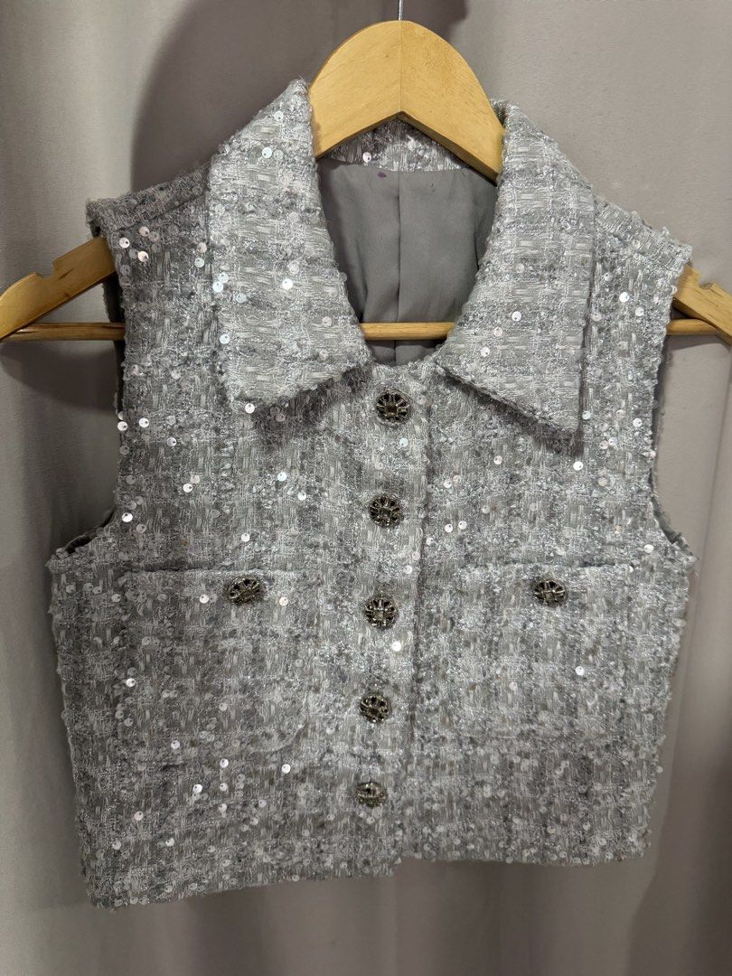 Silver Tweed Sequin Vest Sleeveless Jacket (Category: Sleeveless) located in Manila. Submitted by decluterthings888 (Listing ID 1469961749, Image 1). Description: - Color/Material: Sparkly silver tweed with subtle all-over sequins ❌ NO BRAND❌ - Design: Pointed lapel collar with 5 ornate metal buttons - Pockets: Two front patch pockets with matching decorative buttons - Interior: Fully lined with soft grey fabric - Fit: Sleeveless, cropped cut ide