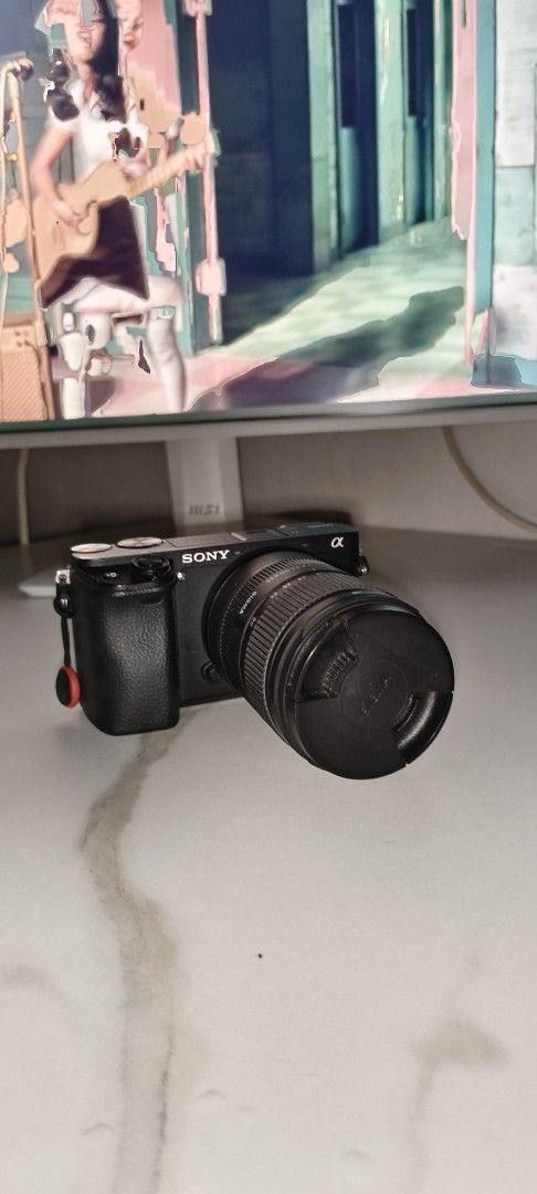 Sony A6400 Alpha Mirrorless Camera with Sigma Lens (Category: Cameras) located in Maasin. Submitted by youngrabbit.da7999 (Listing ID 1470069850, Image 2). Description: - Camera Type: Sony mirrorless camera body - with Sigma 18-50 (minor fungi due to air-conditioning but still photos are crisp and clear) - Condition: Fully functional buttons, screen, and working dials - Extras: 2 Batteries, 64 GB SD CARD, Charger, Cleaning Kit - Ideal Use: Compac