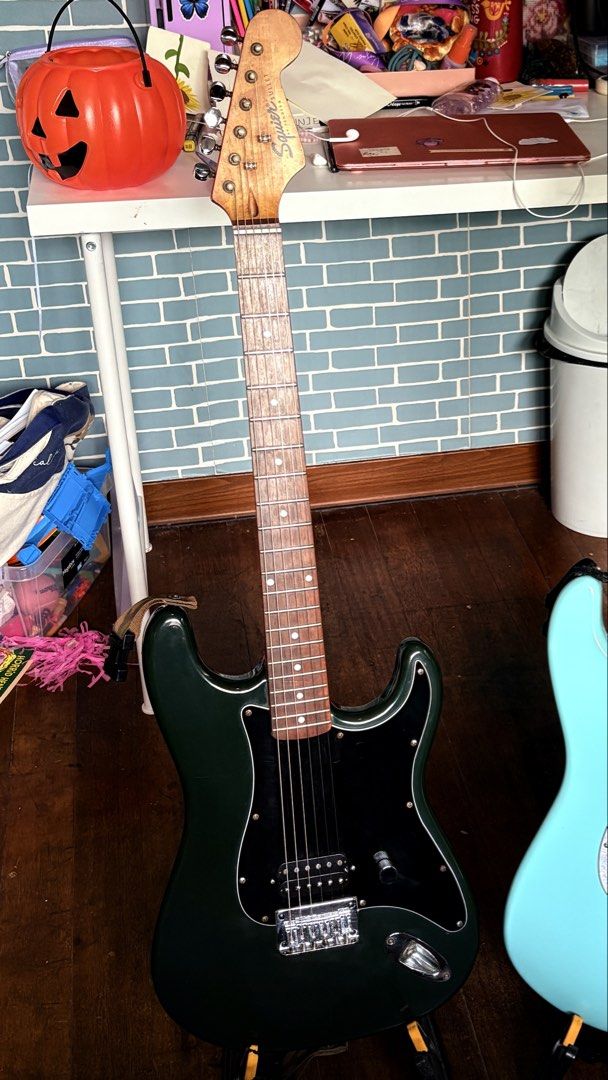 Squier Bullet Stratocaster Electric Guitar (Category: Musical Instruments) located in Quezon City. Submitted by robinjamesmedina (Listing ID 1470080205, Image 1). Description: - Model: Squier Bullet Stratocaster Electric Guitar - Finish: Dark green (originally baltic blue but faded due to age and clear finish yellowing) - Pickups: Single humbucker alnico v copy. layout for a punchy, straightforward rock tone - Hardware: Hardtail tiploader bridge 