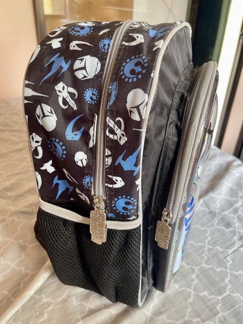 Star Wars Stormtrooper Holographic Kids School Backpack (Category: Babies & Kids Fashion) located in Quezon City. Submitted by shopalluwantbyr (Listing ID 1469982980, Image 2). Description: - Authentic Star Wars backpack with holographic Stormtrooper graphic - All-over pattern featuring Mandalorian helmets, Rebel symbols, and Starfighters - Dual zippered main compartment and front pocket with branded metal pulls - Convenient mesh side pockets for