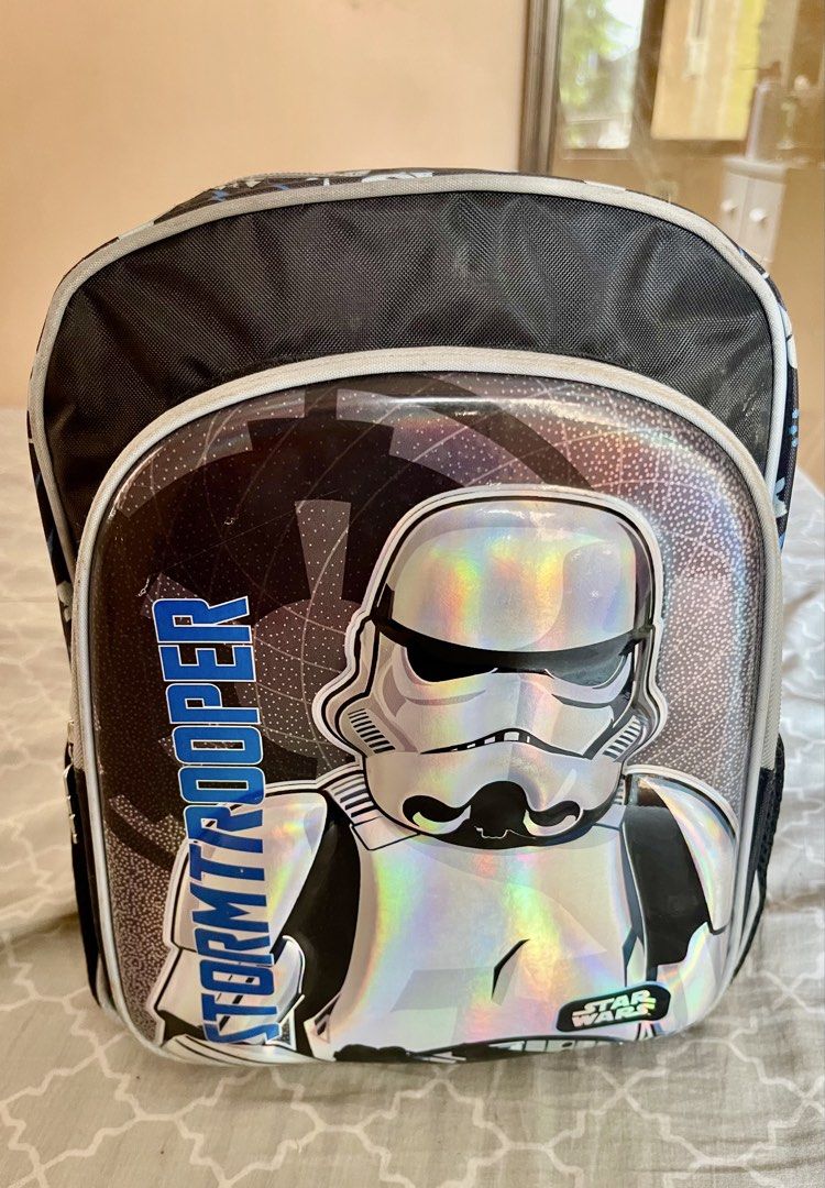 Star Wars Stormtrooper Holographic Kids School Backpack (Category: Babies & Kids Fashion) located in Quezon City. Submitted by shopalluwantbyr (Listing ID 1469982980, Image 1). Description: - Authentic Star Wars backpack with holographic Stormtrooper graphic - All-over pattern featuring Mandalorian helmets, Rebel symbols, and Starfighters - Dual zippered main compartment and front pocket with branded metal pulls - Convenient mesh side pockets for