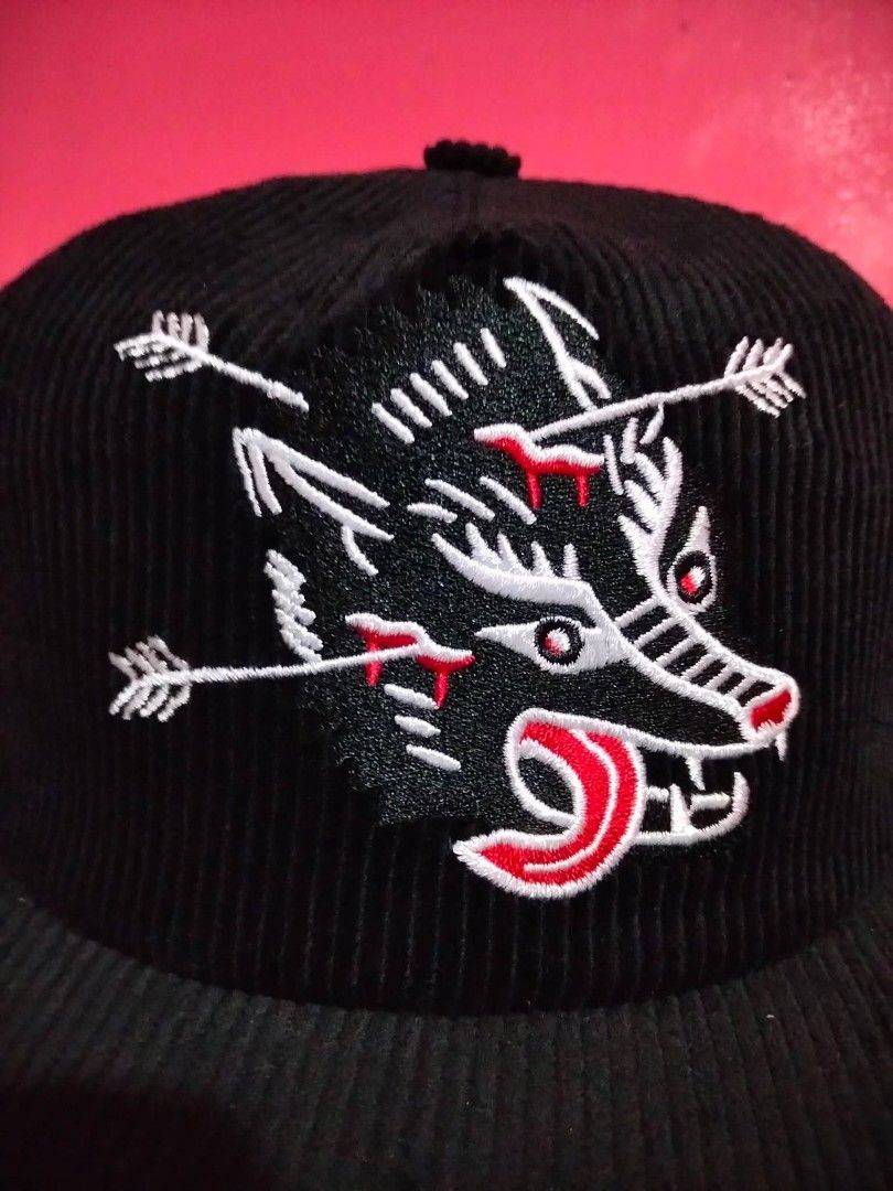 Stuntin Corduroy Black Hat with Wolf Graphic (Category: Caps & Hats) located in Mangaldan. Submitted by niftythrifty69 (Listing ID 1470051572, Image 2). Description: - Color: Black corduroy with textured fabric - Design: Detailed white wolf embroidery pierced by arrows with red bleeding and contrast red stitching - Brand: Stuntin Damn Fine Goods (interior red tag) - Fit: Adjustable snapback closure fits most head sizes - Structure: Structured fro