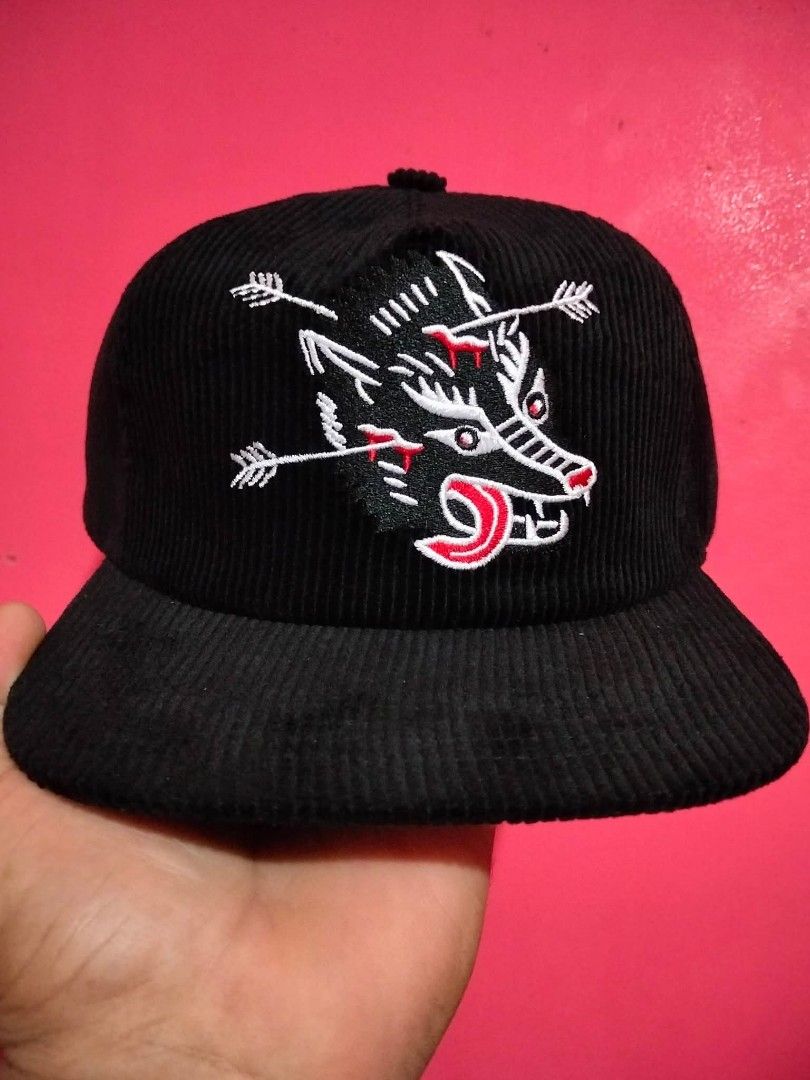Stuntin Corduroy Black Hat with Wolf Graphic (Category: Caps & Hats) located in Mangaldan. Submitted by niftythrifty69 (Listing ID 1470051572, Image 1). Description: - Color: Black corduroy with textured fabric - Design: Detailed white wolf embroidery pierced by arrows with red bleeding and contrast red stitching - Brand: Stuntin Damn Fine Goods (interior red tag) - Fit: Adjustable snapback closure fits most head sizes - Structure: Structured fro