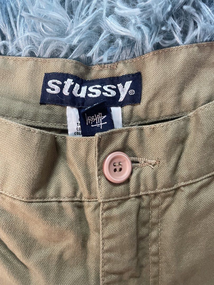 Stussy Khaki Cargo Shorts Size 36 (Category: Shorts) located in Manila. Submitted by jssur (Listing ID 1470083976, Image 2). Description: - Brand: Stussy - Item: Khaki Cargo Shorts - Size: 36 - Made in: China - Fit: Relaxed streetwear fit - Details: Button fly with pinkish button closure, multiple side and back cargo pockets, double knee panels - Branding: Stussy interior waistband tag and small logo tag near pocket.