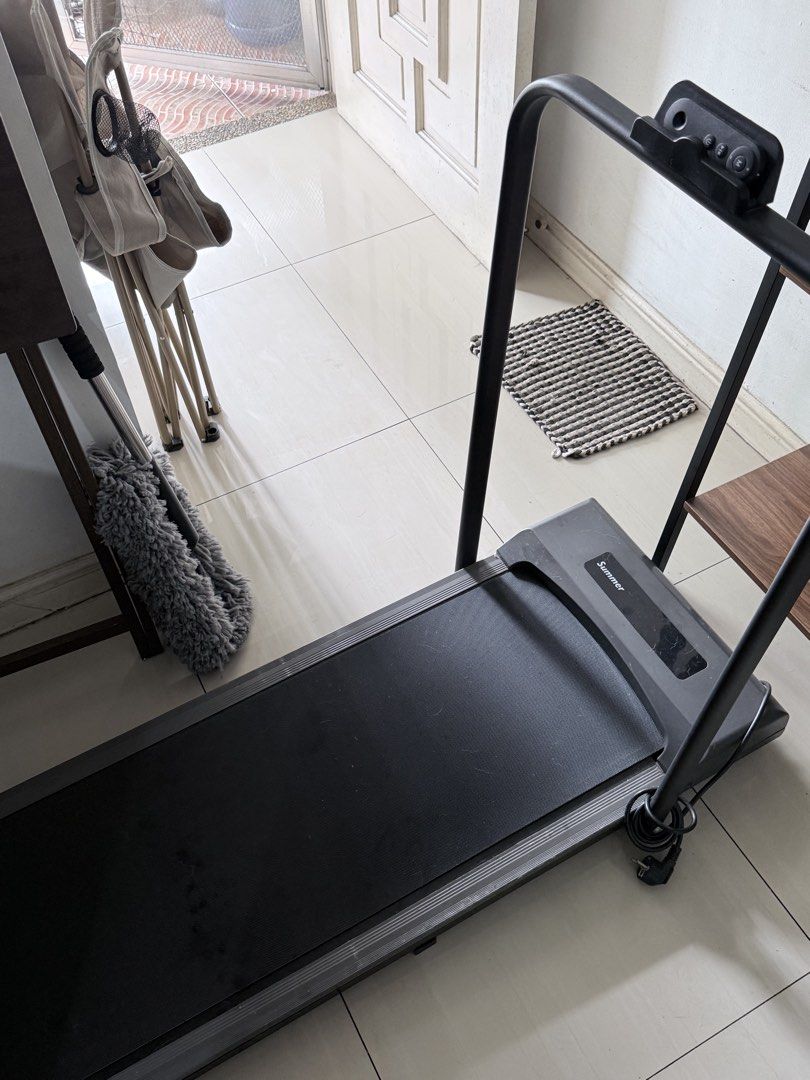 Summer Folding Treadmill Walking Pad (Category: Cardio & Fitness Machines) located in Pasig City. Submitted by shop.gelss (Listing ID 1469973554, Image 2). Description: - Brand: Summer - Type: Compact walking pad / under-desk treadmill - Color: Sleek black finish - Design: Slim profile, ideal for small spaces and under-desk use - Features: Built-in control console on the handlebar - Power: Standard plug attached at the base - Condition: Powers on
